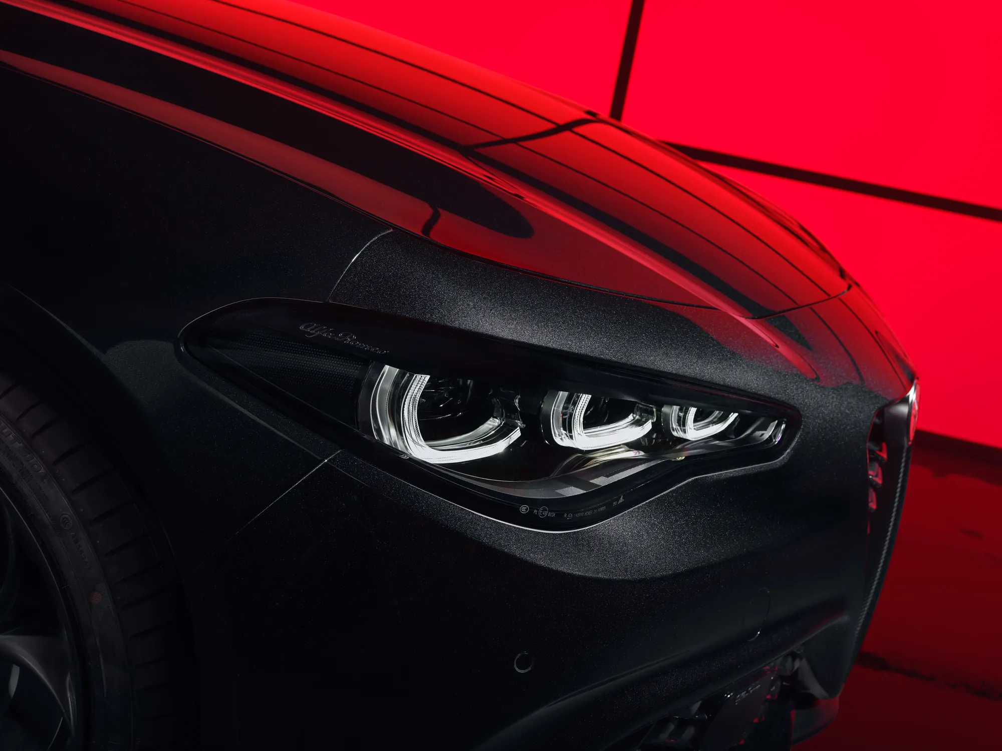 Faro a LED della Alfa Romeo Giulia Luna Rossa sullo sfondo rosso